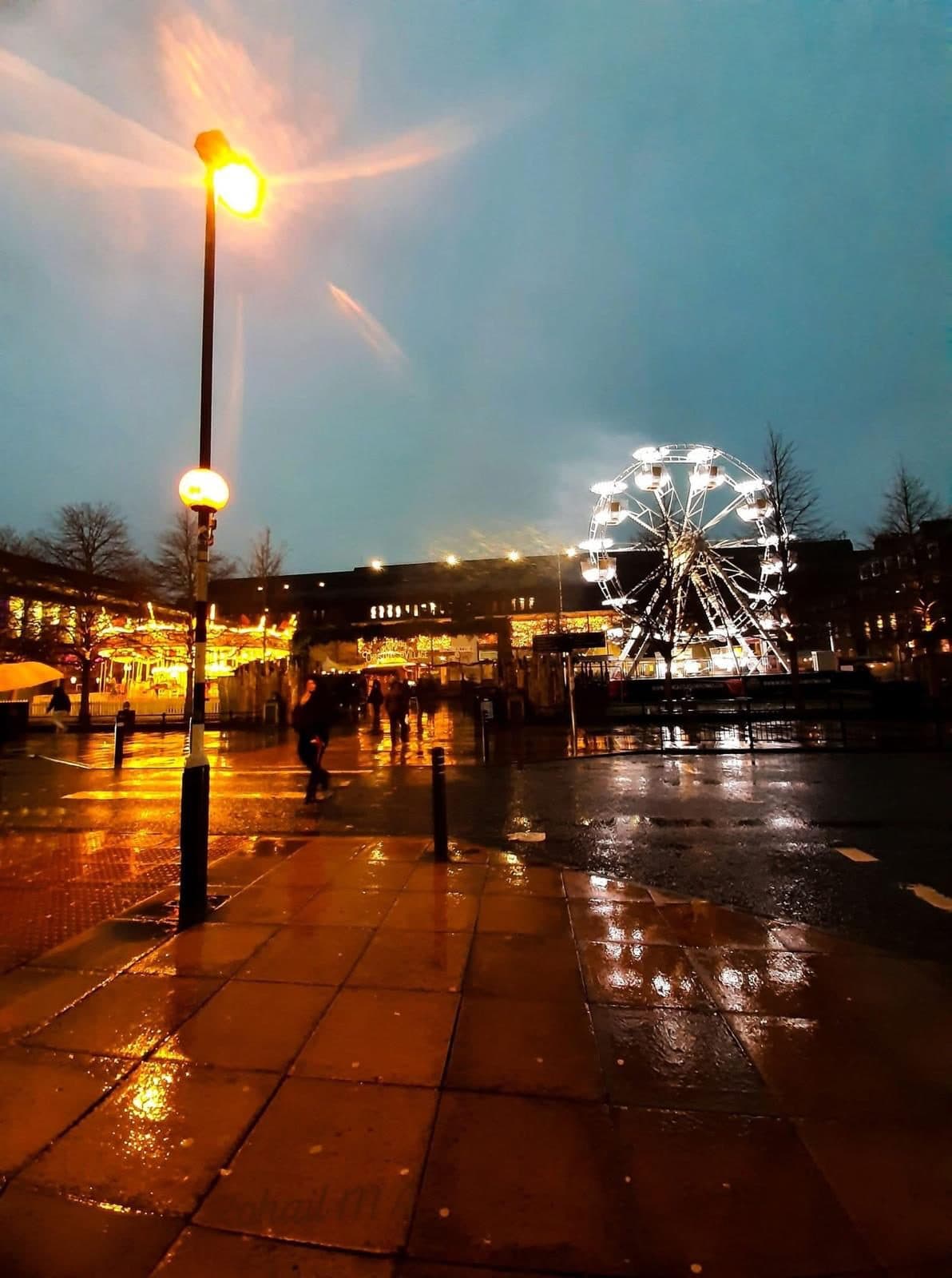 A UK city street at dusk during the Christmas markets